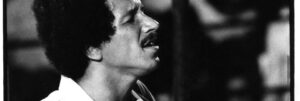 Black and white film photograph of Keith Jarrett playing piano live.