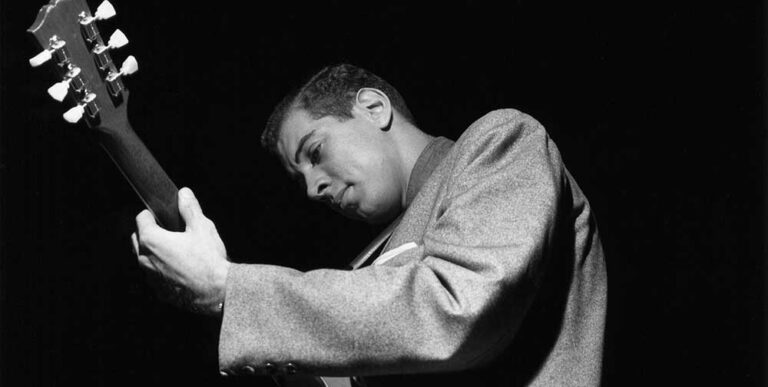 Black and white photograph of Kenny Burrell playing guitar by Francis Wolff.