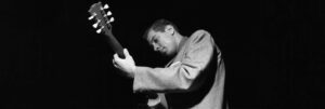 Black and white photograph of Kenny Burrell playing guitar by Francis Wolff.