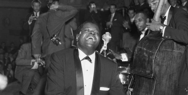 Black and white photo of the Oscar Peterson Trio performing live in front of an audience.