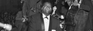 Black and white photo of the Oscar Peterson Trio performing live in front of an audience.