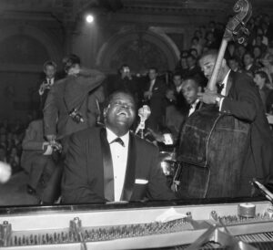 Black and white photo of the Oscar Peterson Trio performing live in front of an audience.