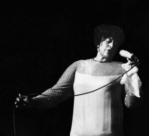 Black and white photograph of Jazz singer Ella Fitzgerald performing live.